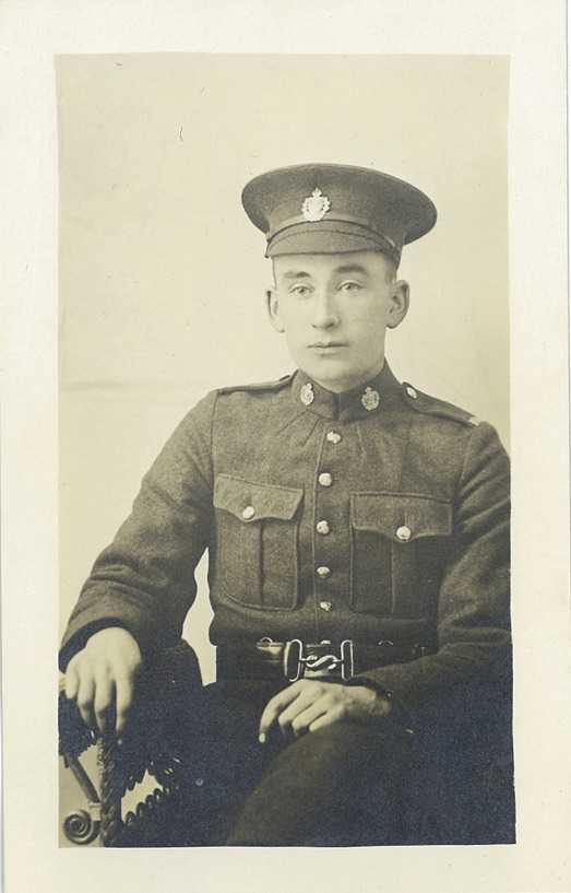 Black and white portrait. Archie poses seated, in uniform, during the First World War